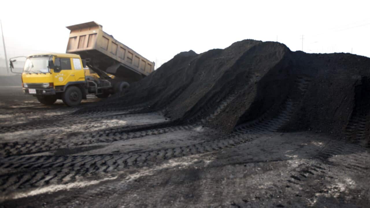 A truck unloads coal.