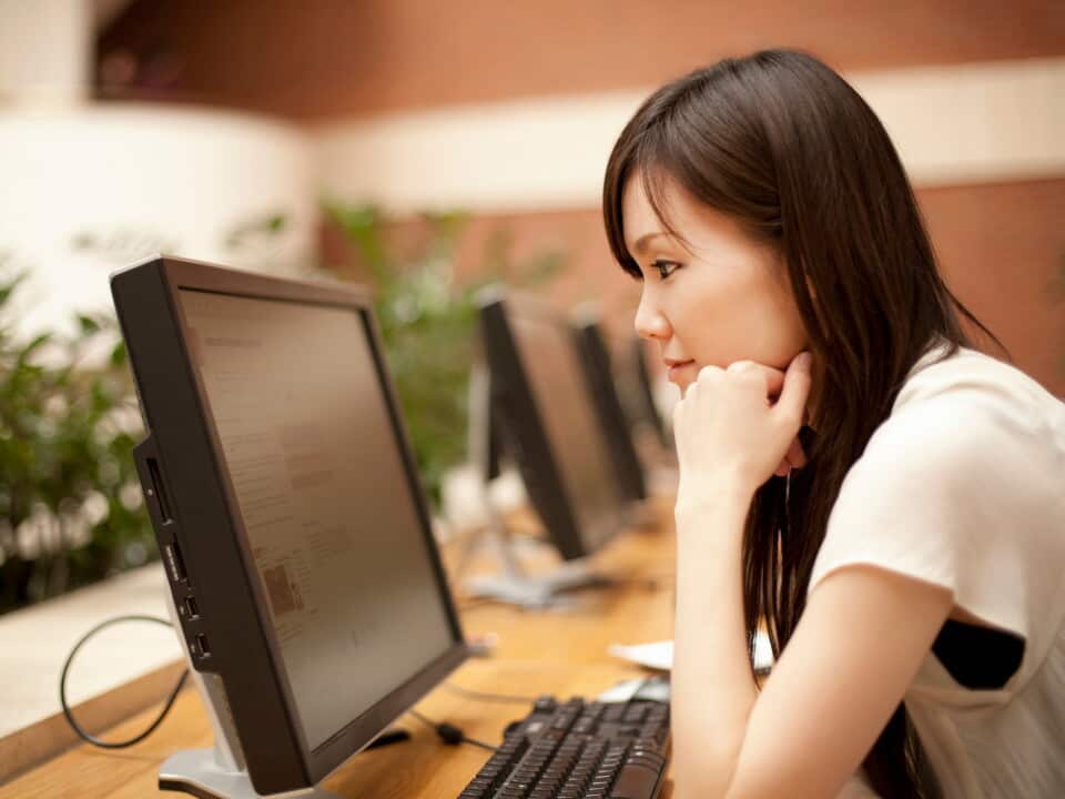 Mid adult woman looking at computer monitor