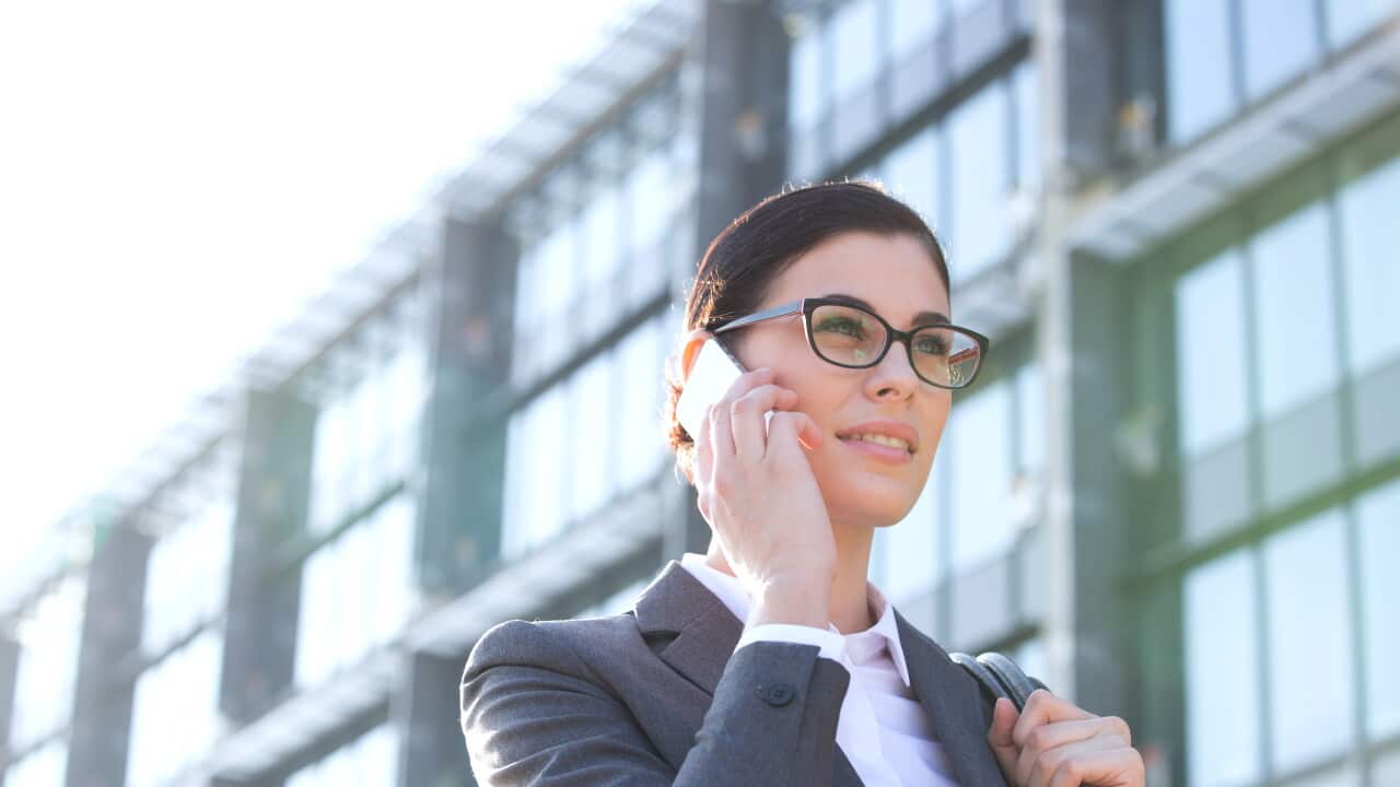 Low angle view of businesswoman using cell phone outside office building