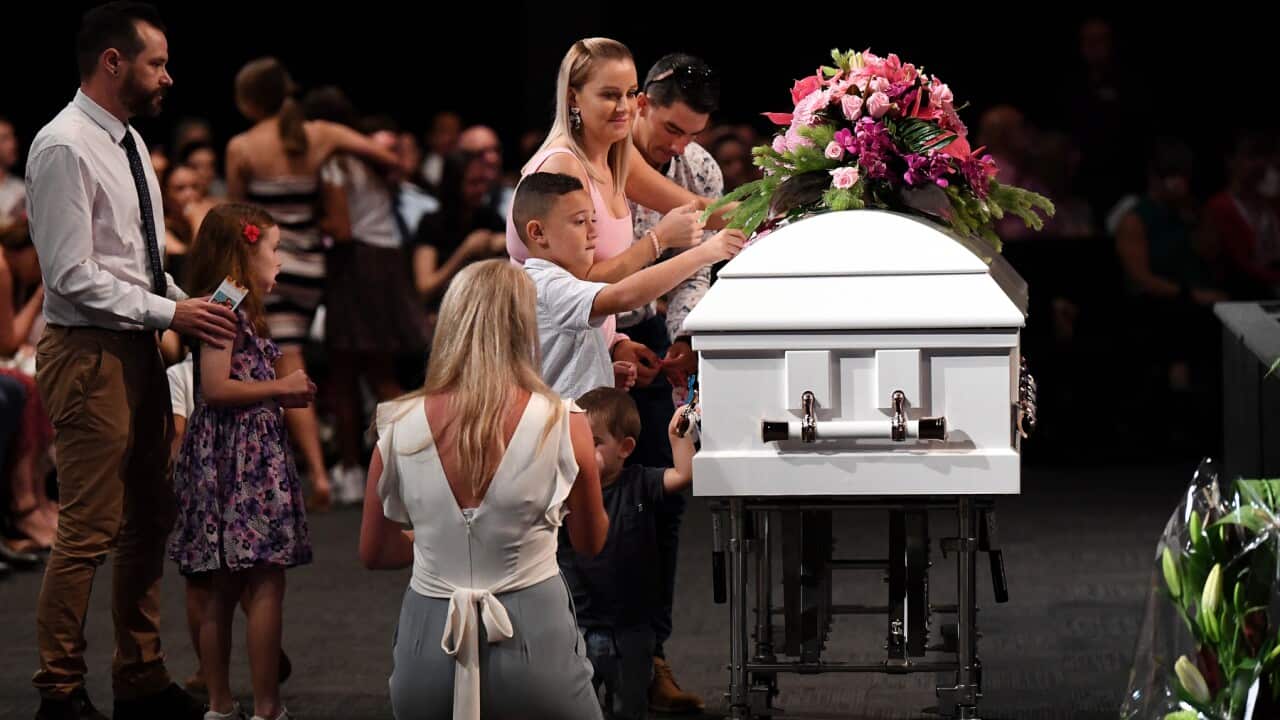 Children place butterfly stickers on the coffin during the funeral for Hannah Clarke and her three children