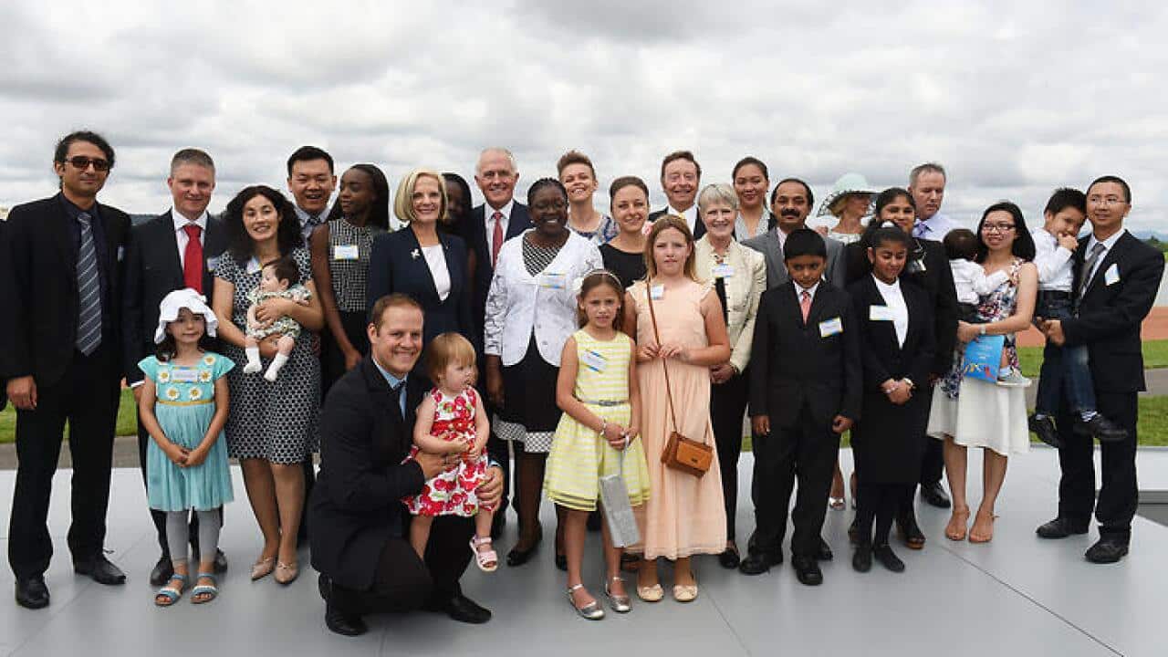 Prime Minister Malcolm Turnbull (C) with newly sworn Australian citizens at an Australia Day Citizenship Ceremony.