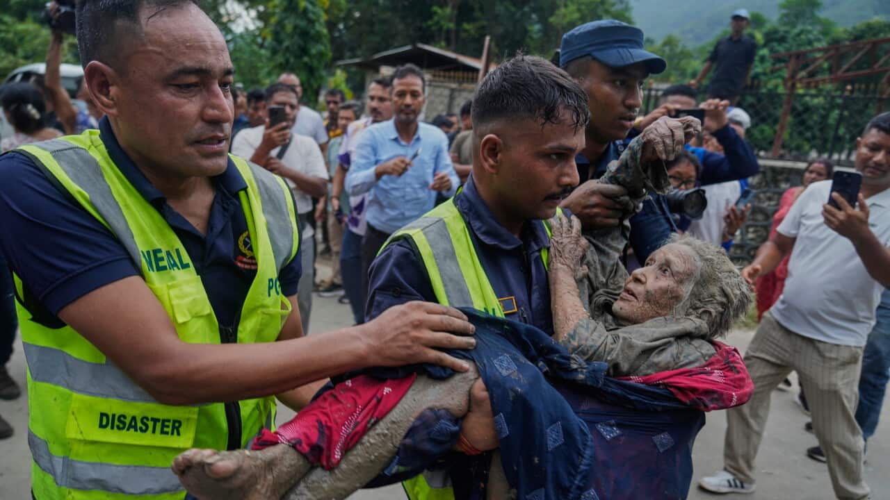 Rescuers carry a victim to safety in Nepal - AAP