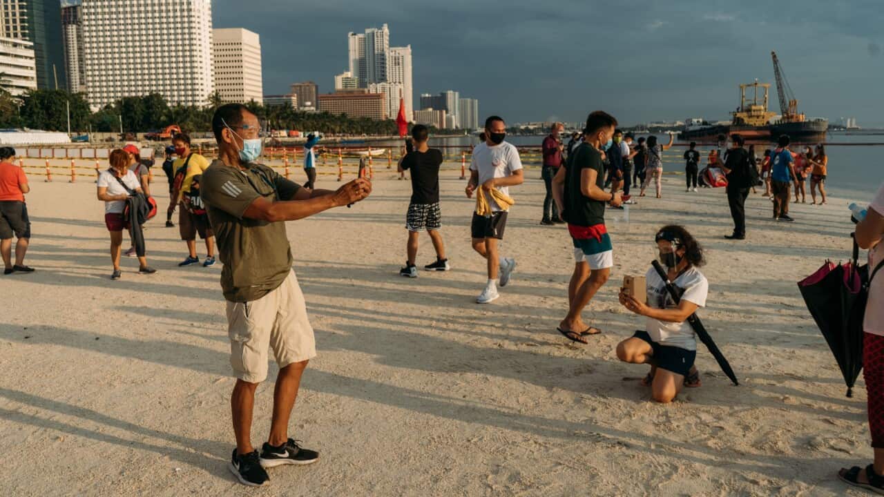 Filipinos are seen taking pictures inside the designated artificial 'white sand' area of the Manila Bay beach, crushed dolomite were dumped as part of the government's efforts to rehabilitate and beautify the polluted coastline. On September 20, 2020 in M