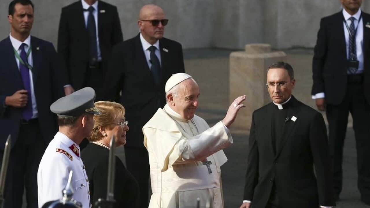 Pope Francis waves with Chile's President Michelle Bachelet.