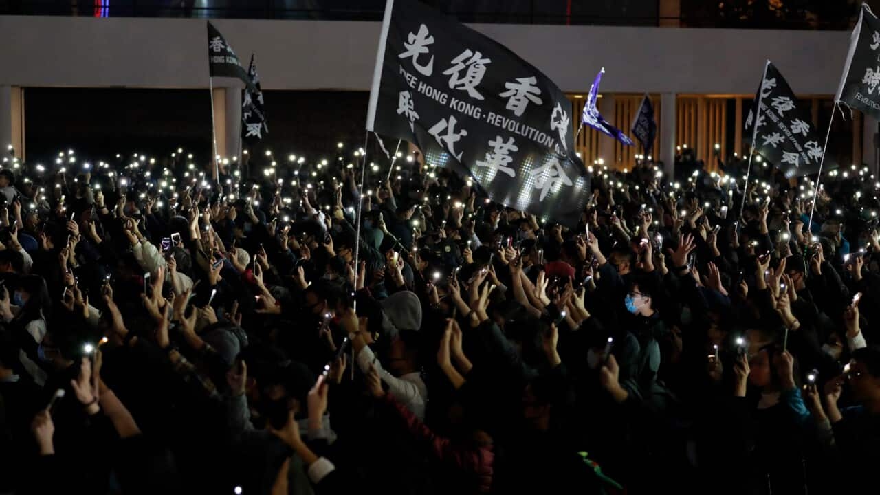 Protesters hold up their smartphone lights and their hands