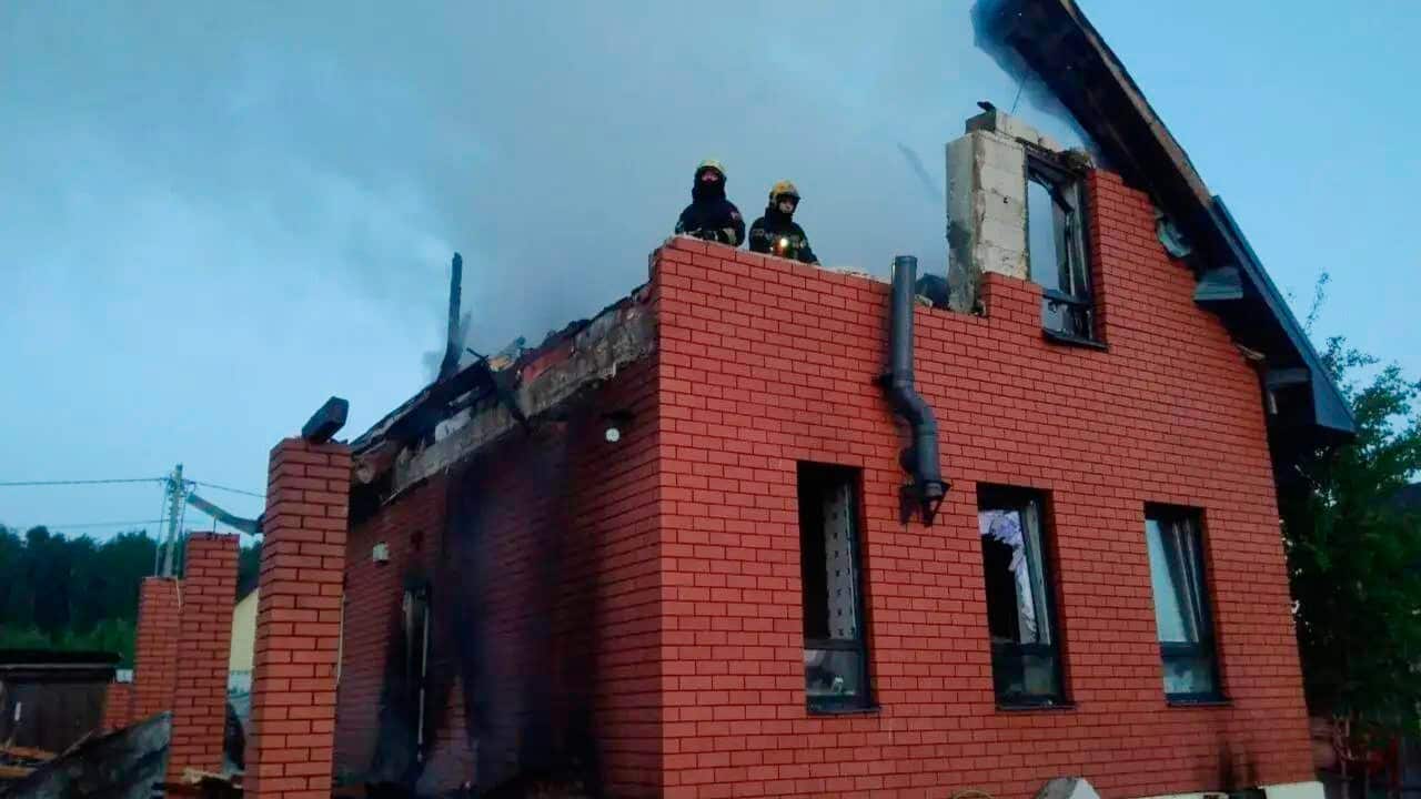 Two people stand at the top of a destroyed building