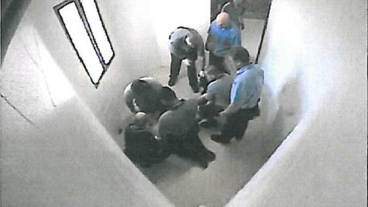 Guards surround a child in a Townsville detention centre in Queensland.