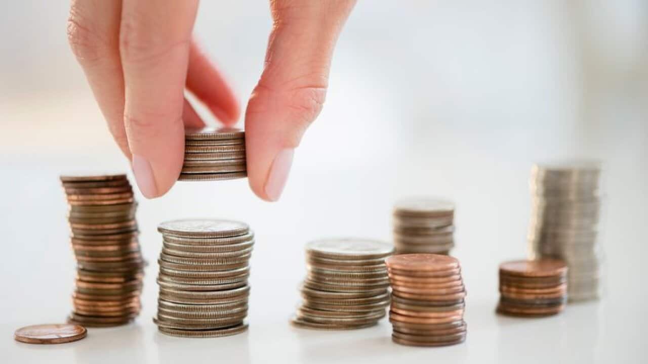 Mixed race woman stacking coins