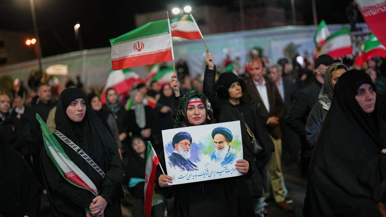 A woman holds a poster during a pro-government gathering in a square in Tehran (AAP).