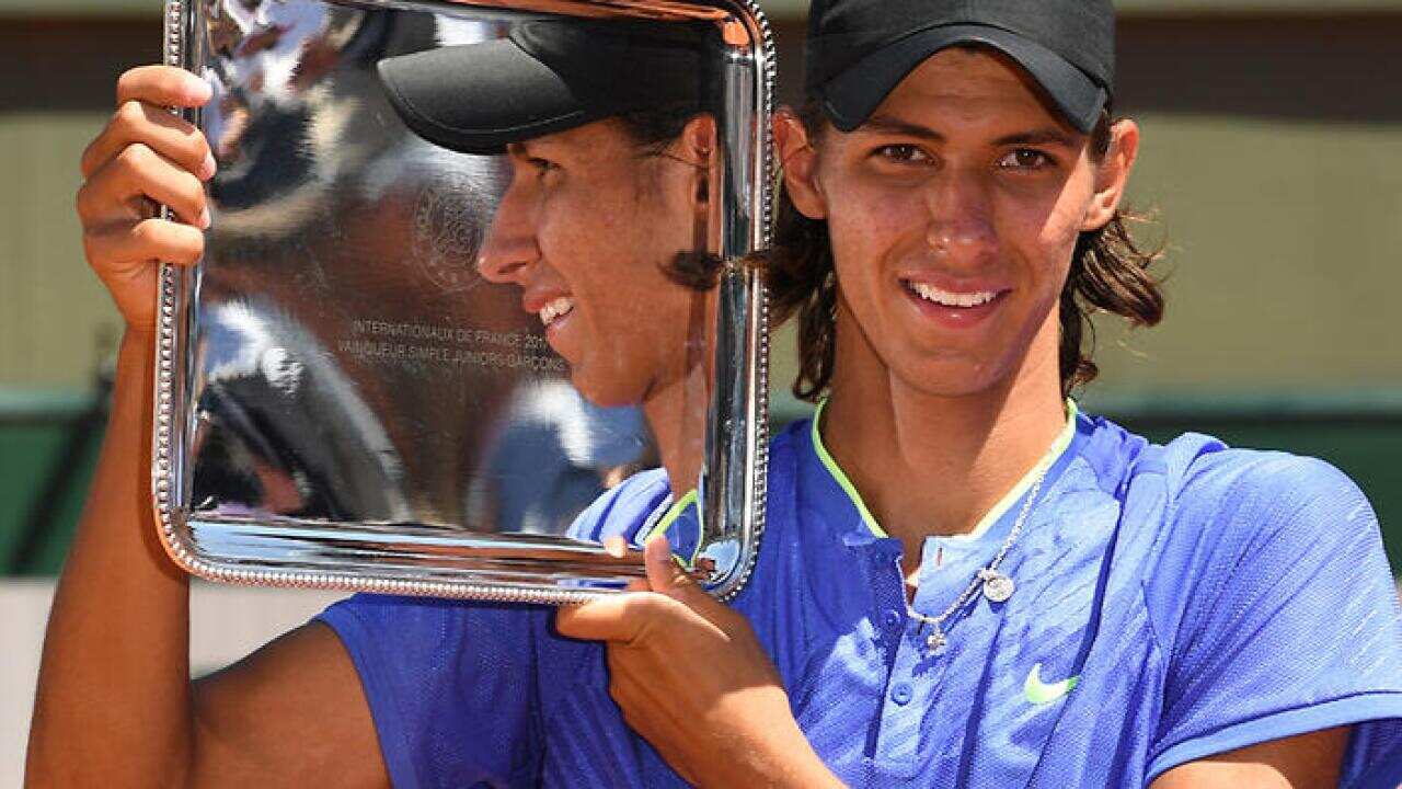 Alexei Popyrin of Australia poses with his trophy after winning against Nicola Kuhn of Spain their boy's singles final match during the French Open tennis tournament at Roland Garros in Paris, France