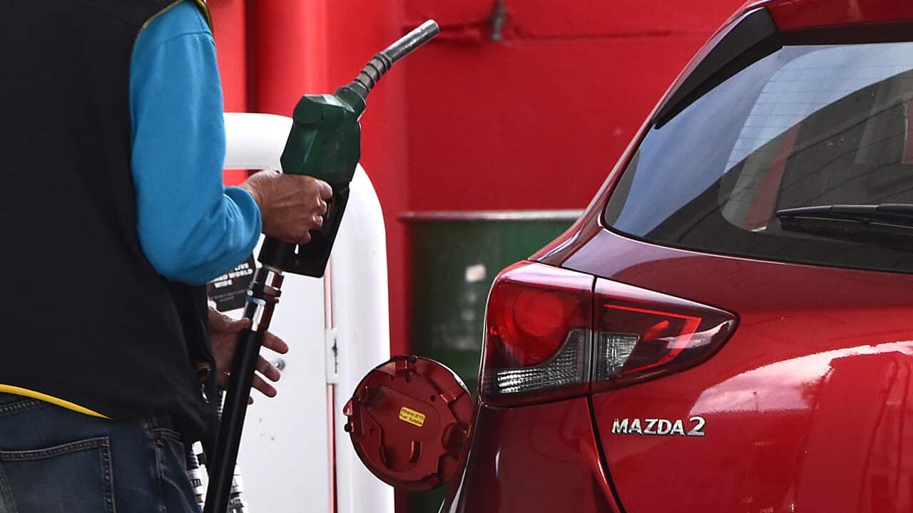 A person at the pump at a petrol station.