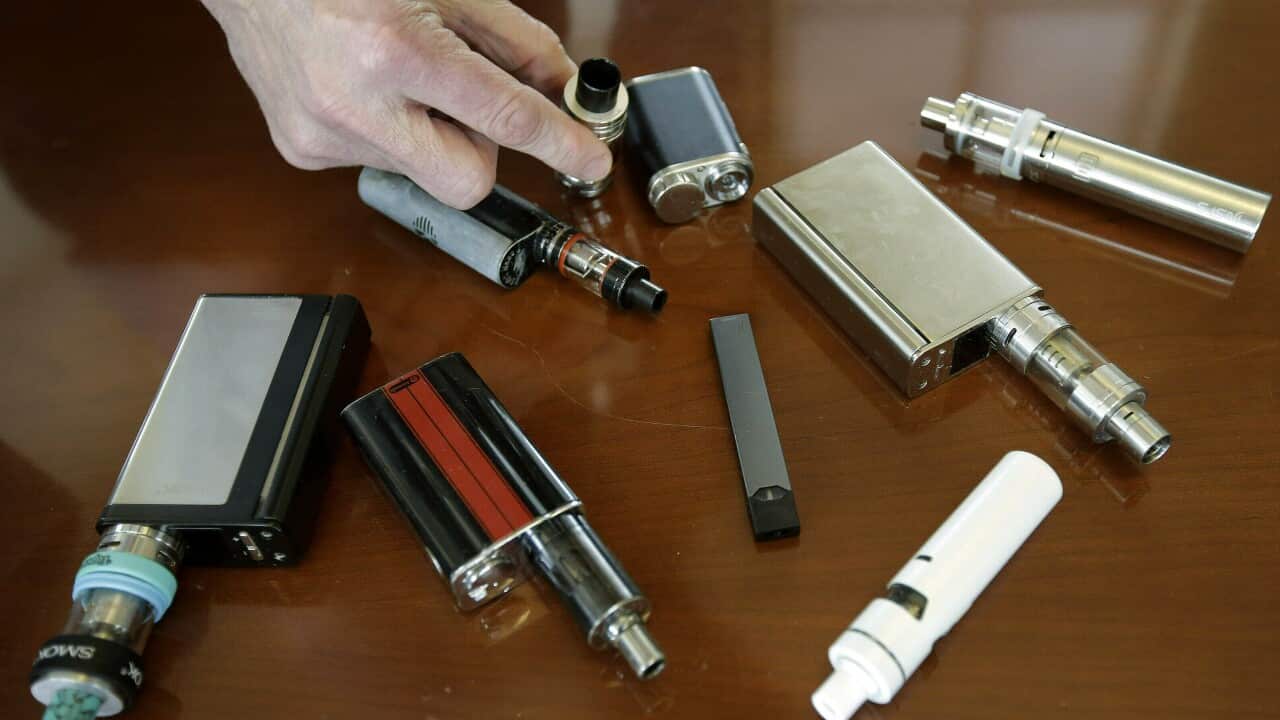 A high school principal displays vaping devices that were confiscated from students in restrooms or hallways