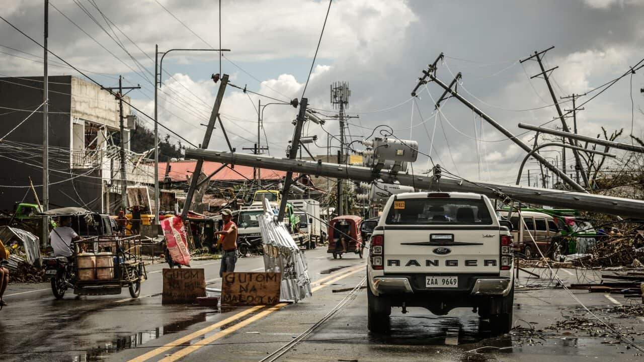 Fallen electric pylons block a road in Surigao City, Surigao del norte province, on 19 December, 2021, days after super Typhoon Rai devastated the city.
