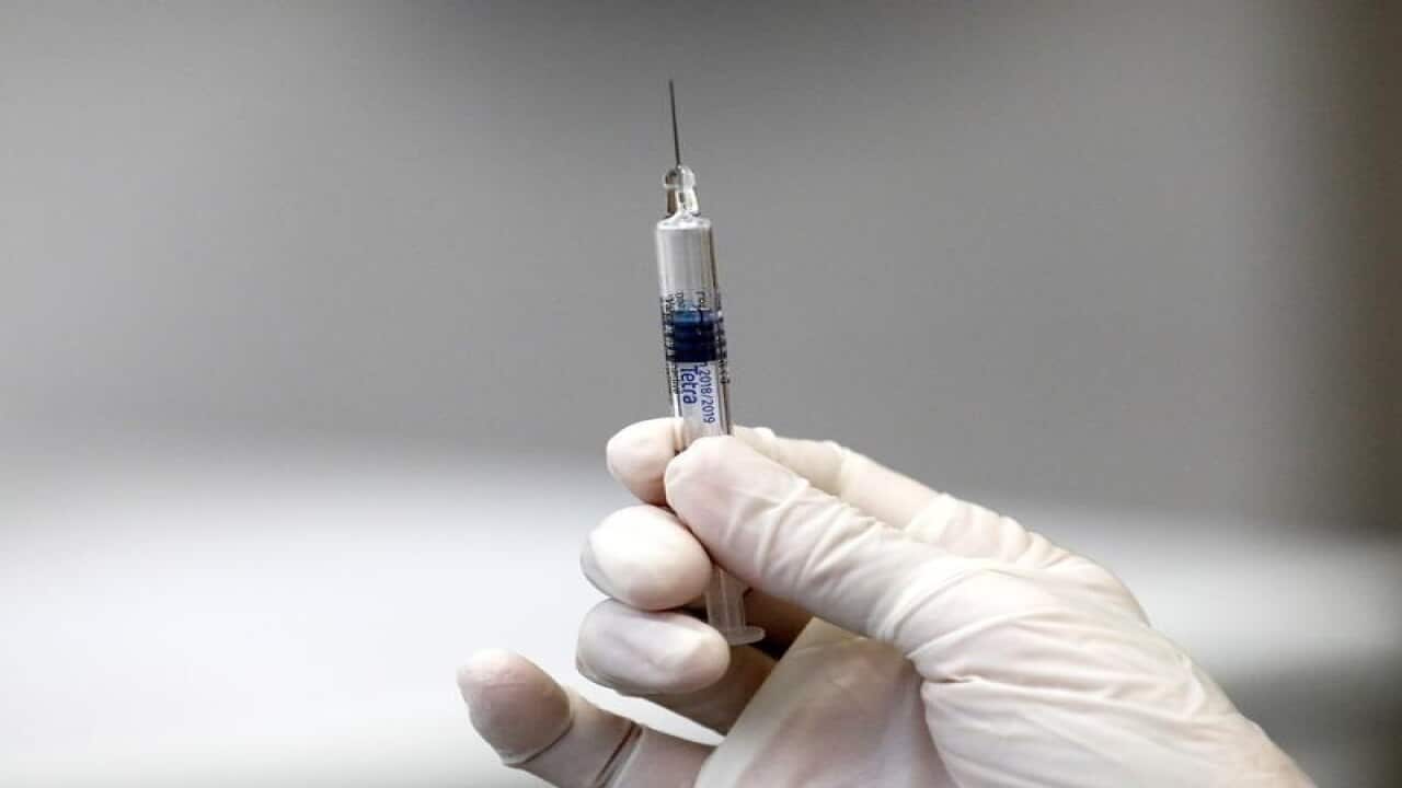 A person holds an injection with an influenza vaccine