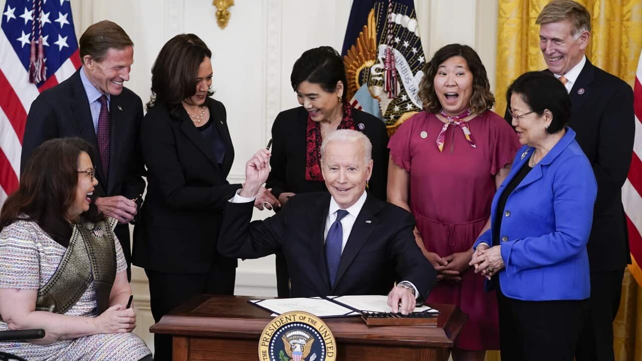 President Joe Biden hands out a pen after signing the COVID-19 Hate Crimes Act