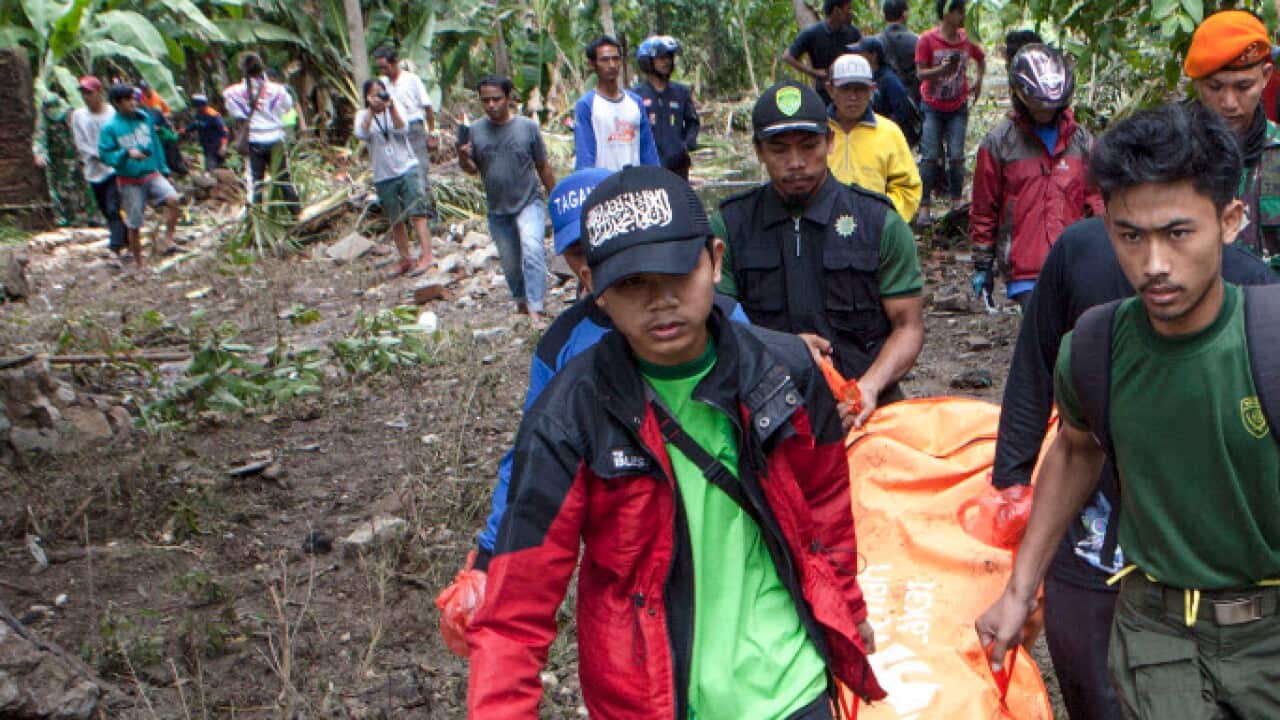 Indonesian volunteers carry a body after a tsunami on Anyer Beach in Karang Sugara village, Anyer, Banten, Indonesia, 24 December 2018 (AAP)