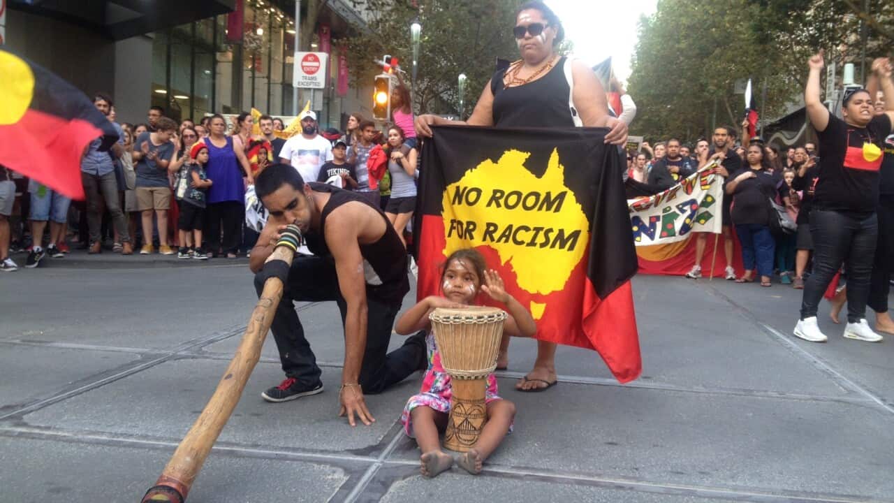 A man plays the didgeridoo as protesters in Melbourne stop traffic on March 19, 2015 to rally against the planned closure of up to 150 remote communities in Western Australia