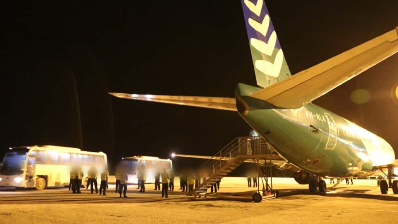 Asylum seekers board an airplane on Christmas Island