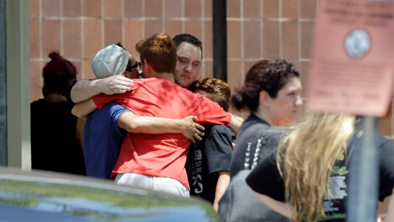 People react outside the unification center at the Alamo Gym, following a shooting at Santa Fe High School Friday, May 18, 2018