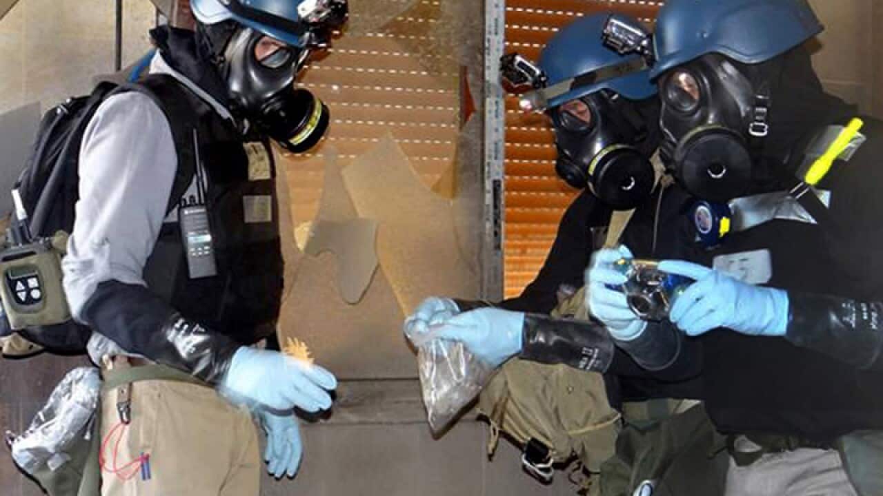 Members of the UN investigative team take chemical weapons sample