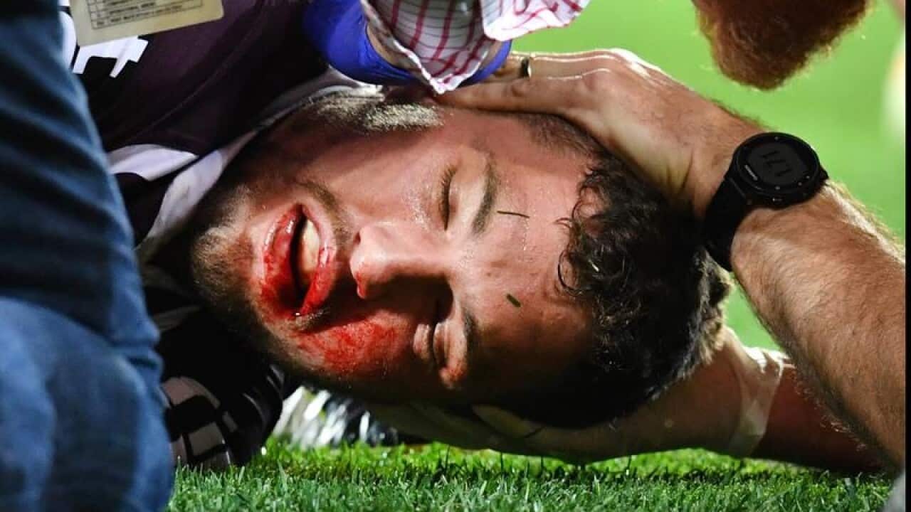 Corey Oates of the Broncos is treated by medical staff.