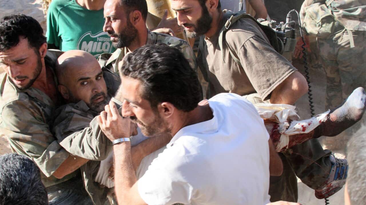 Syrian army soldiers evacuate their commander who was injured, Syria