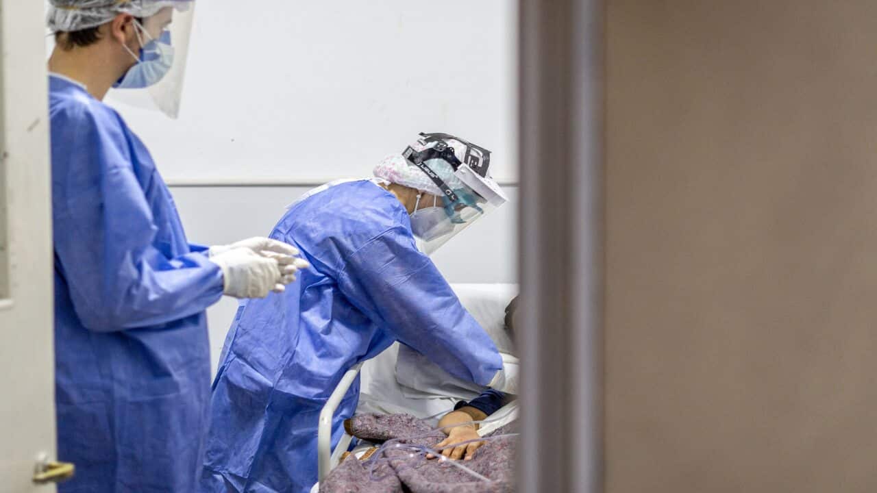 A nurse checks on a coronavirus patient.