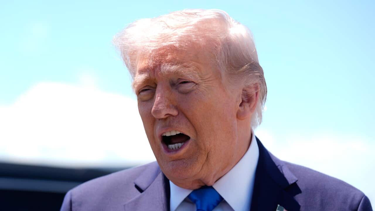 A man in a suit and tie speaks