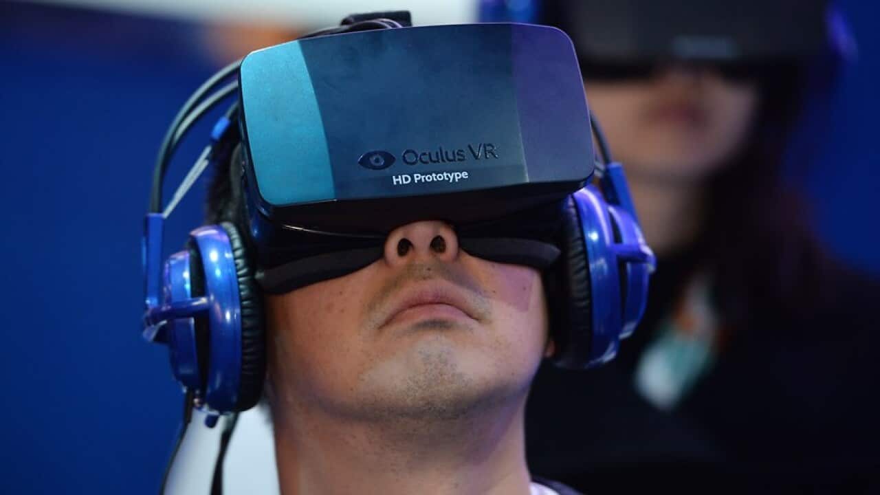 A man wears an Oculus Rift HD virtual reality head-mounted display at he plays a shooter game.