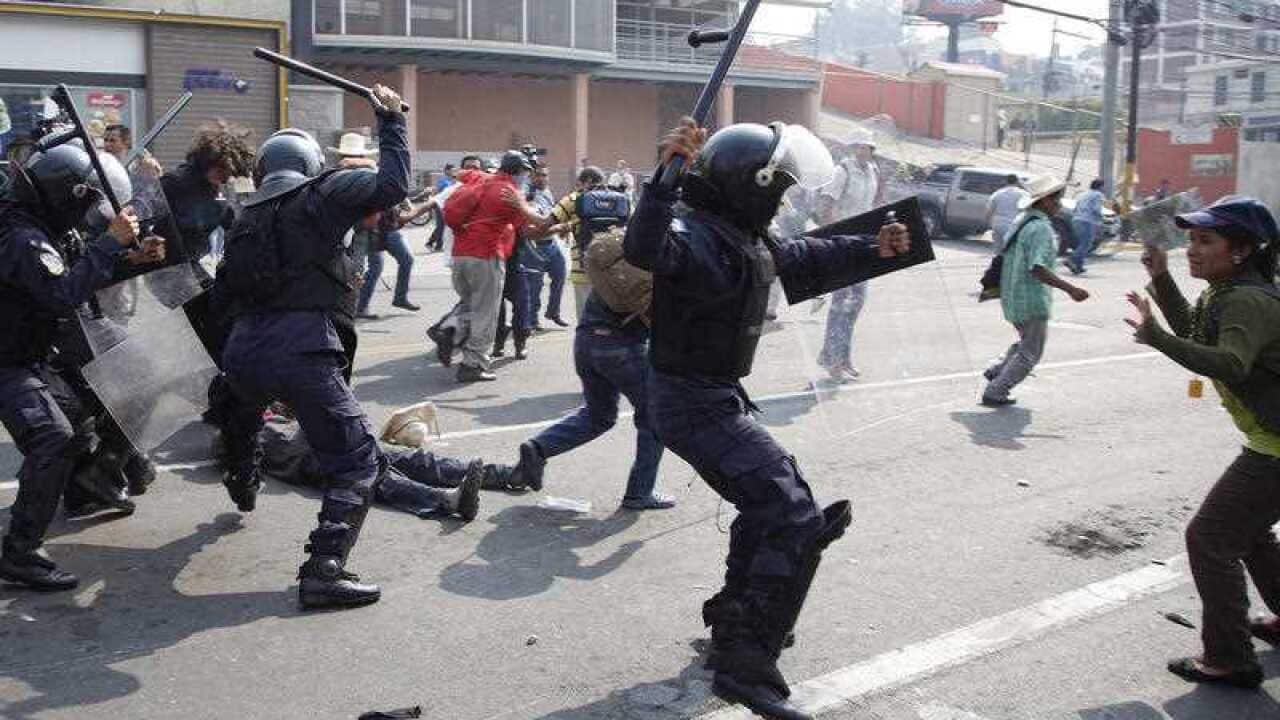 Police attack protesters outside the presidential office in Tegucigalpa, Honduras, Monday, May 9, 2016, after demonstrators tried to break past the security perimeter while demanding justice for the March murder of environmentalist and indigenous leader B