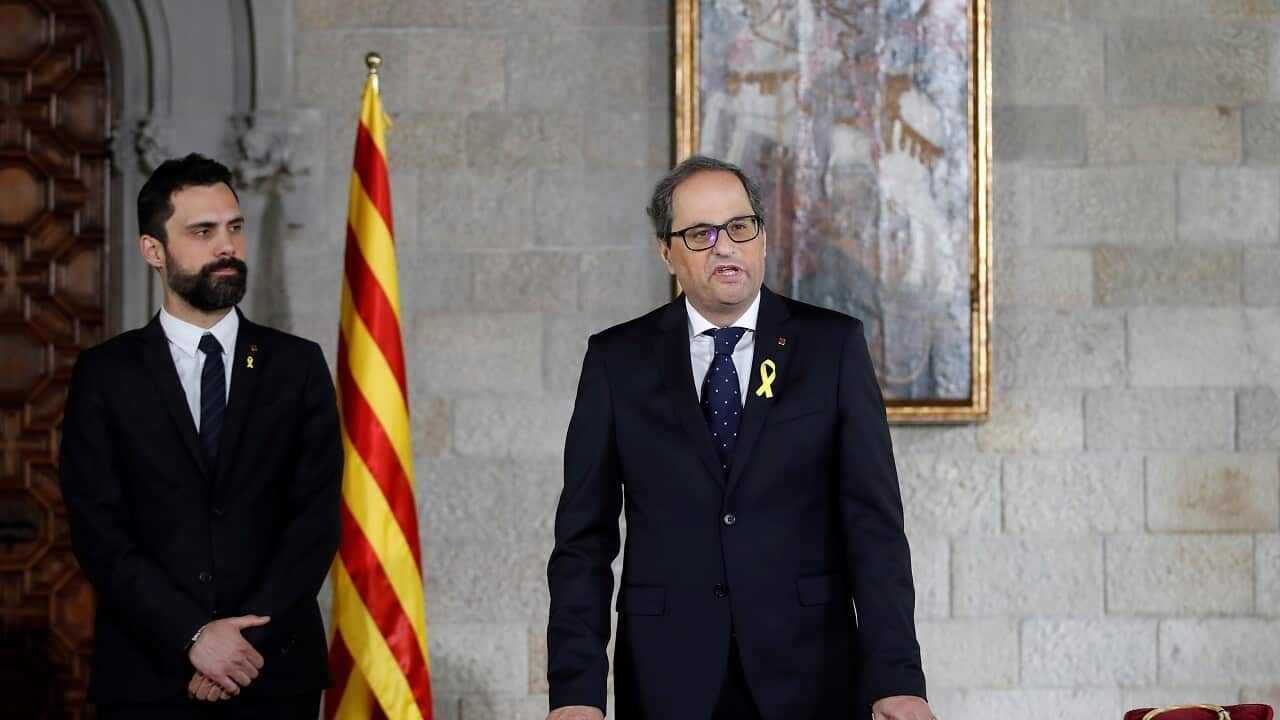 New Catalan President Quim Torra, right, talks during a swearing in ceremony.