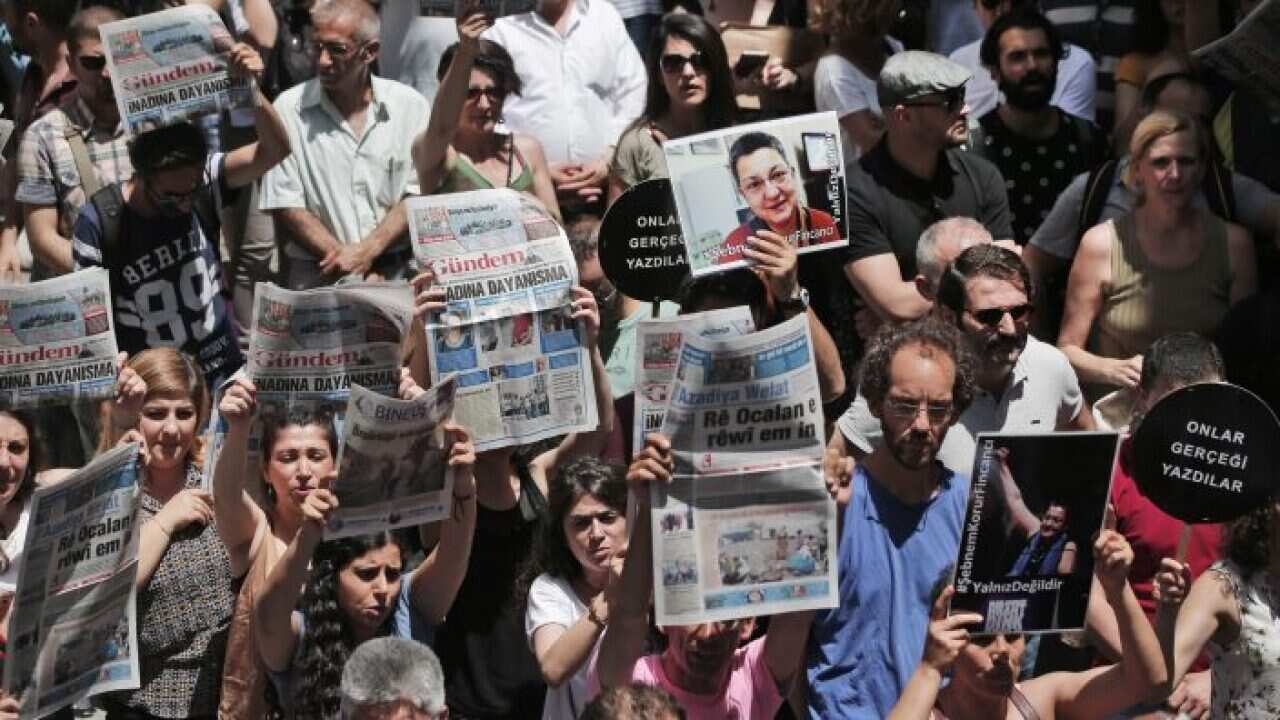 Protesters demonstrate against the jailing of two journalists and an academic, outside the offices of Ozgur Gundem in Istanbul, Turkey