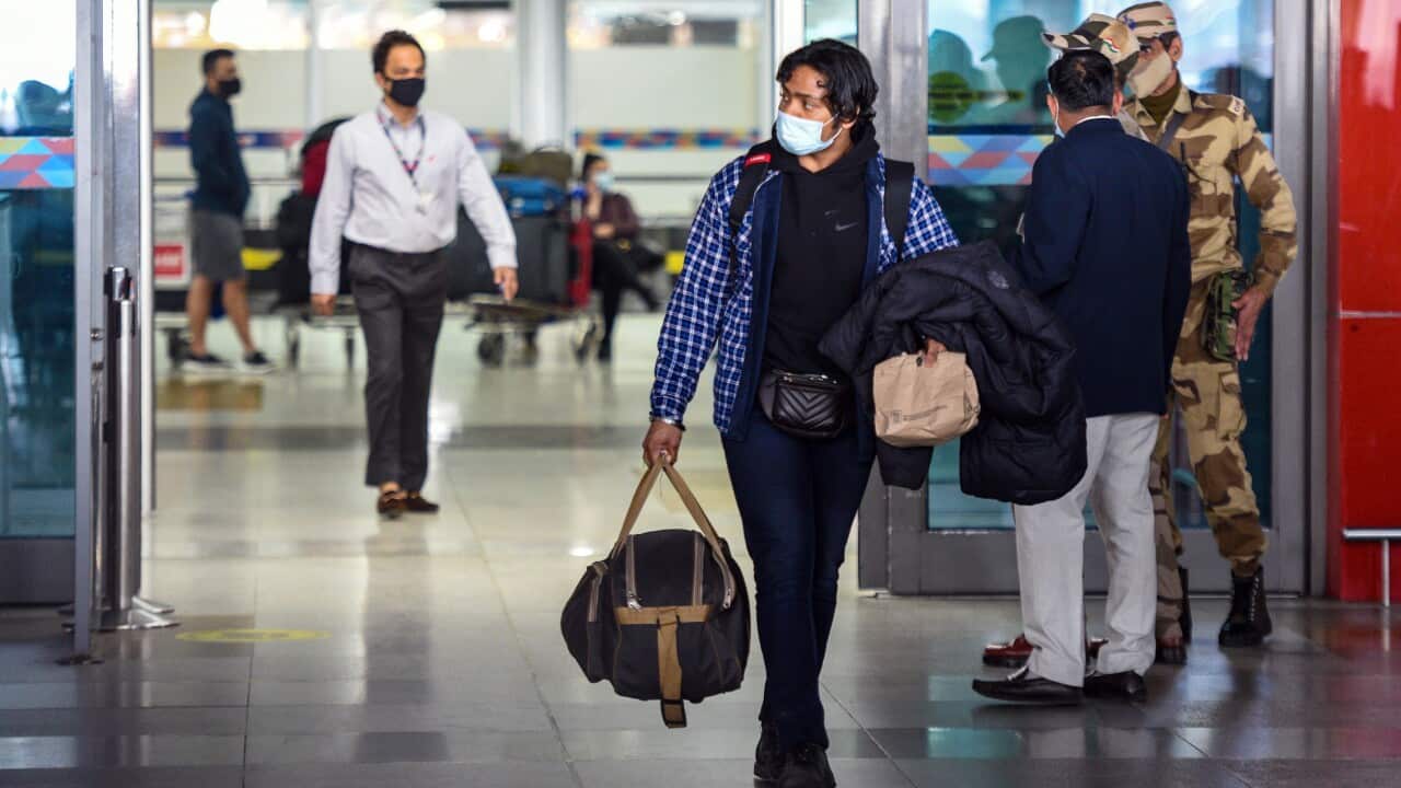 A person carrying a bag as they leave an airport.