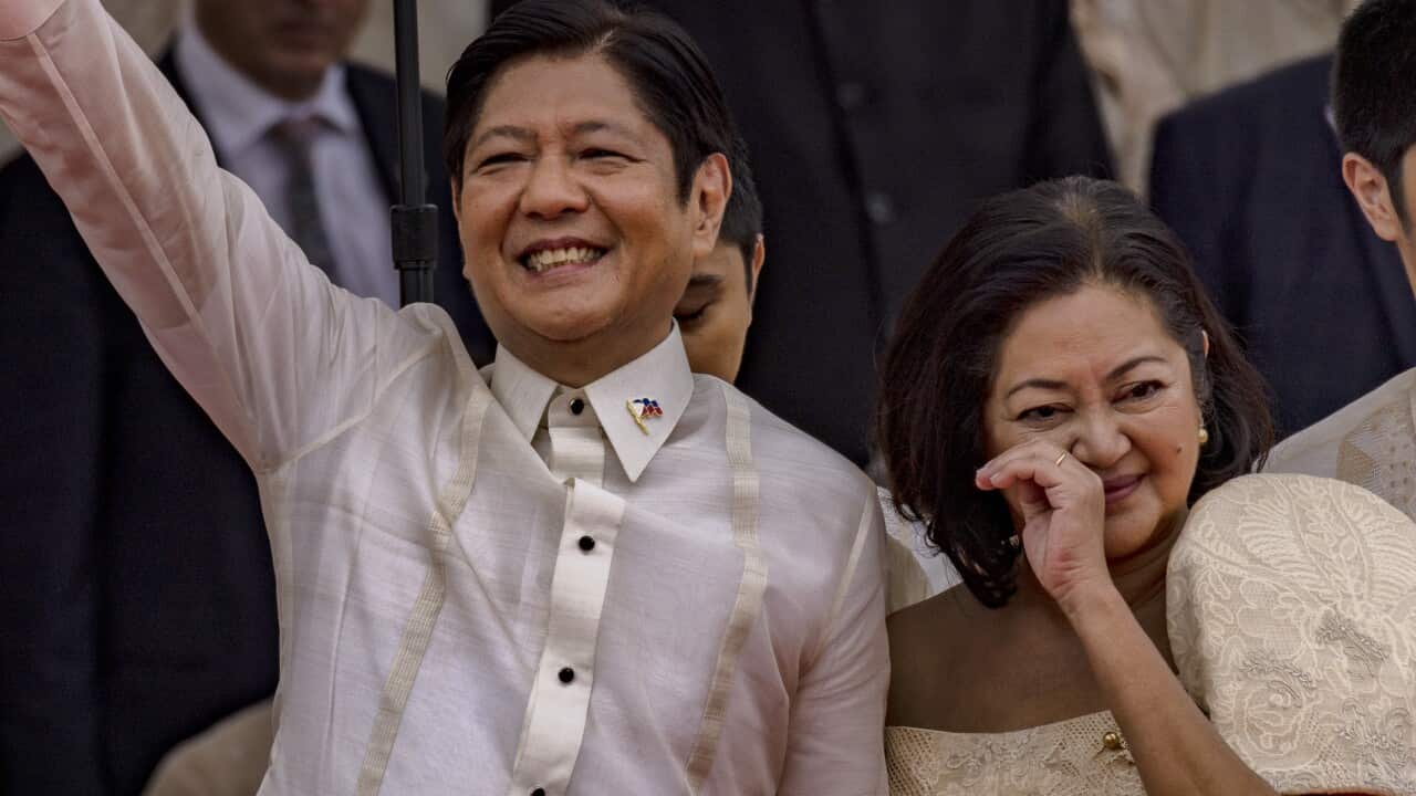 A man waving while holding a woman's hand.
