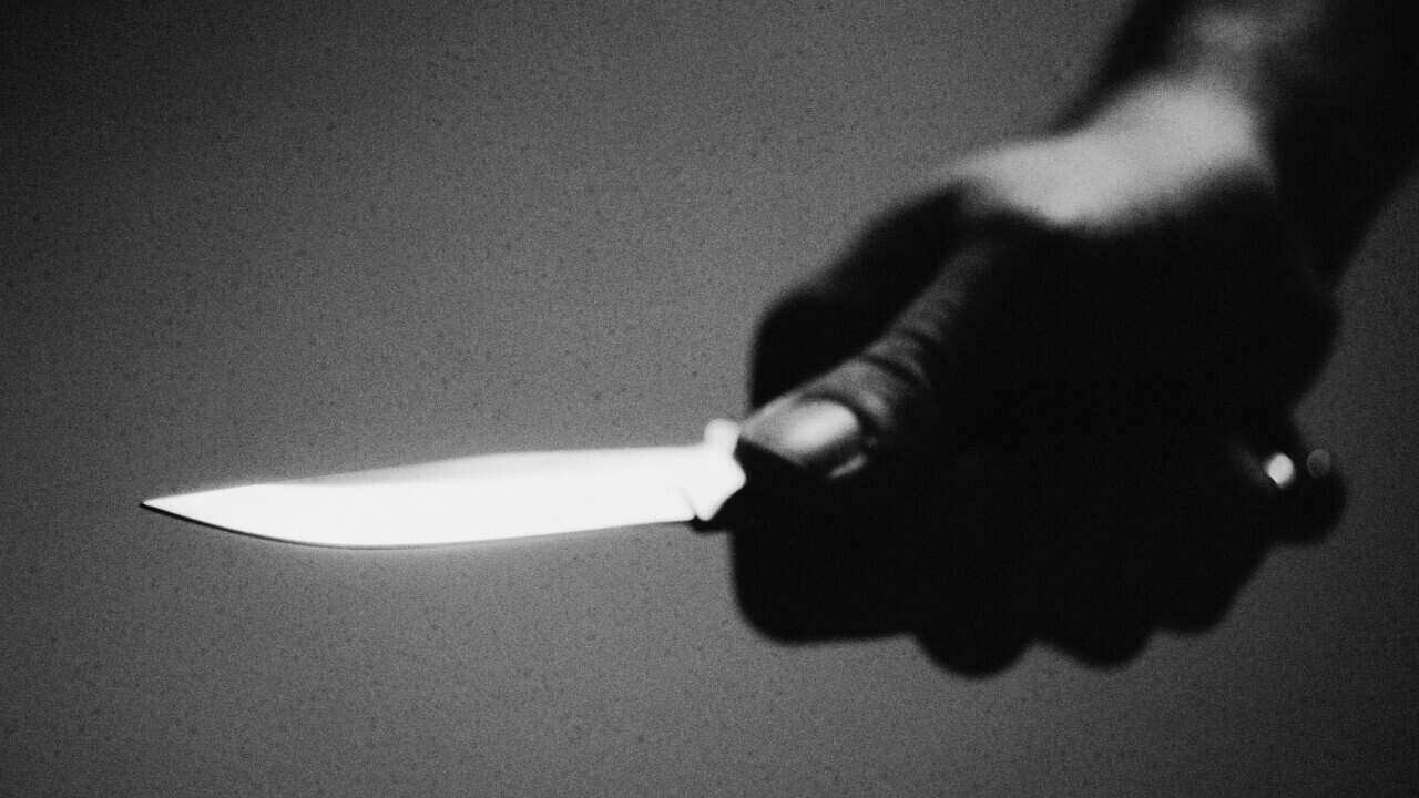 Hand holding knife, close-up, b&w