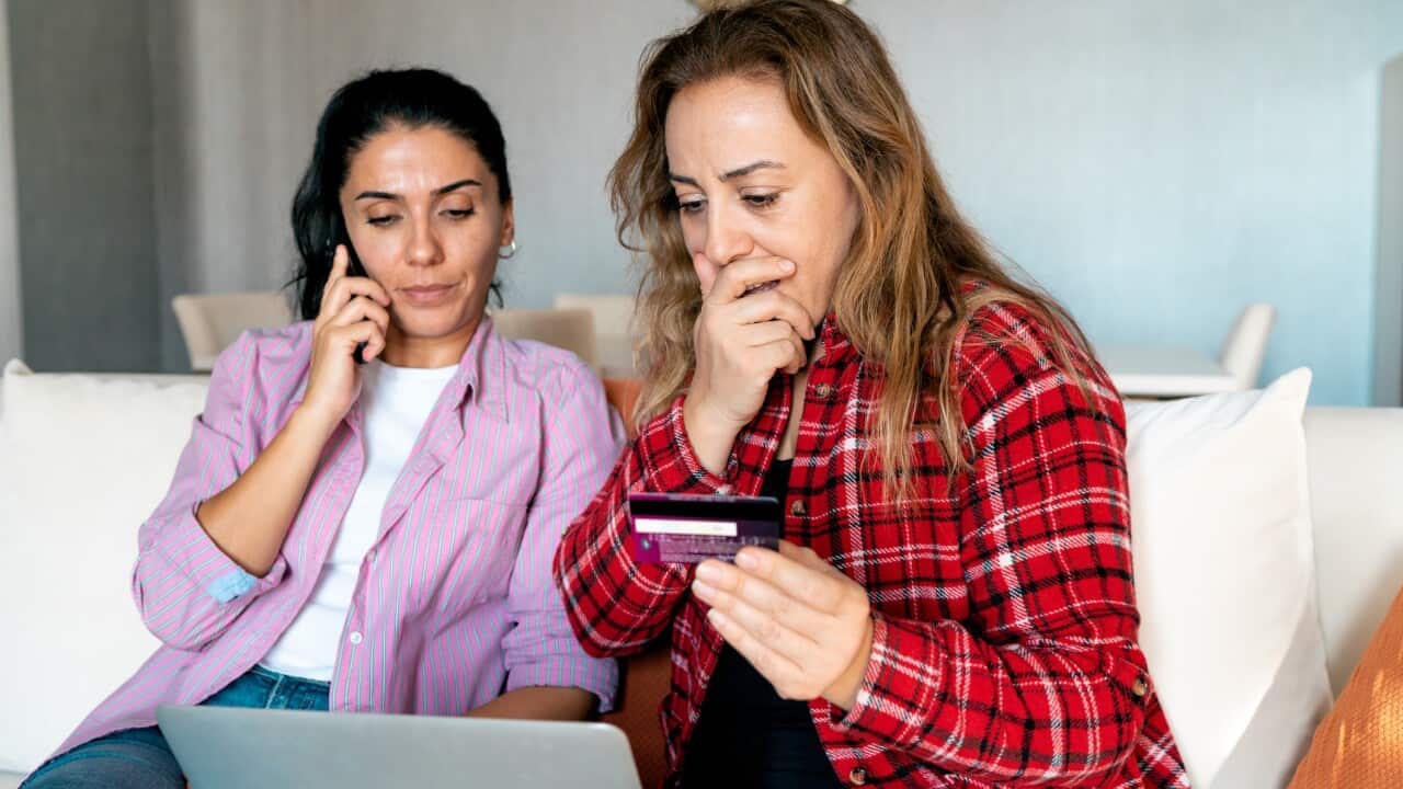 Stressed upset woman holding bank card and being surprised.png