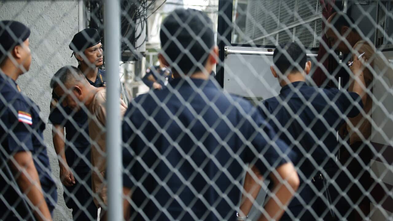 Thai police stand guard as suspects in a human trafficking case arrive at a Bangkok court on 19 July 2017.