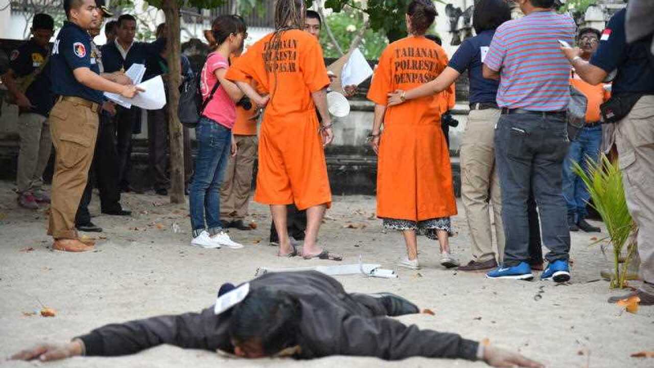 Australian woman Sara connor and British man David Taylor reenact a crime scene on Kuta beach