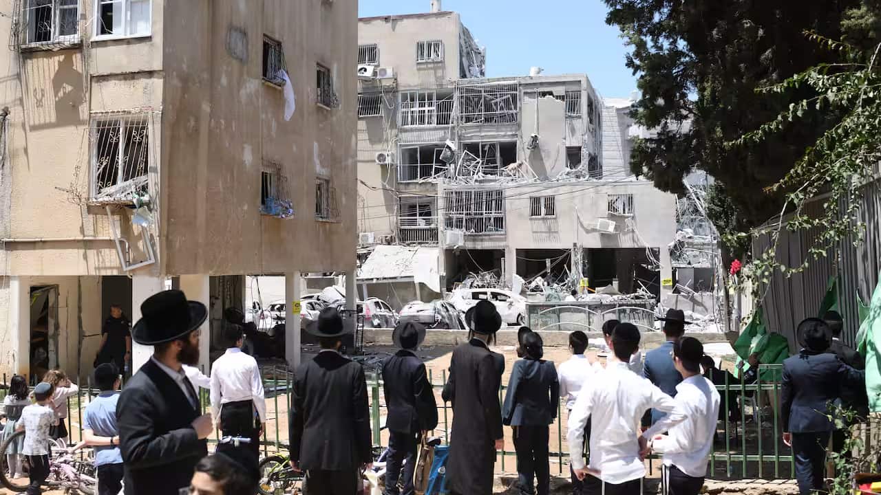 People looking at a building that has been destroyed_.png
