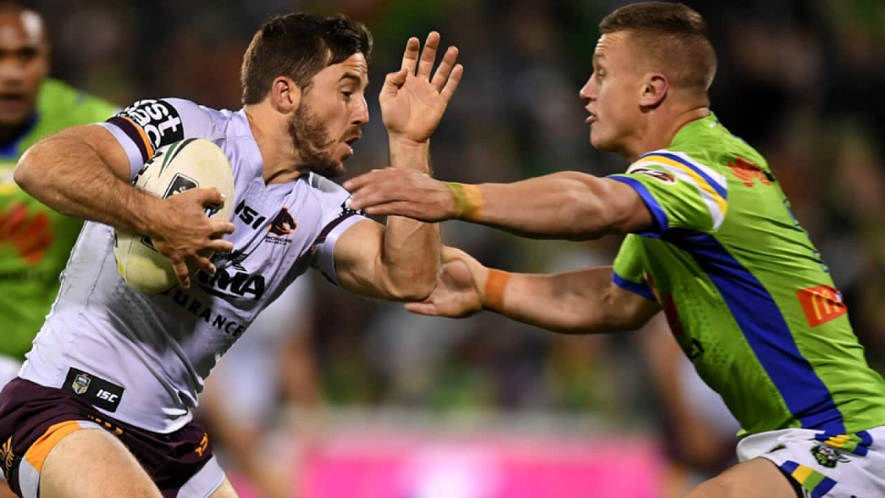 Ben Hunt of the Broncos (left) is tackled by Jack Wighton