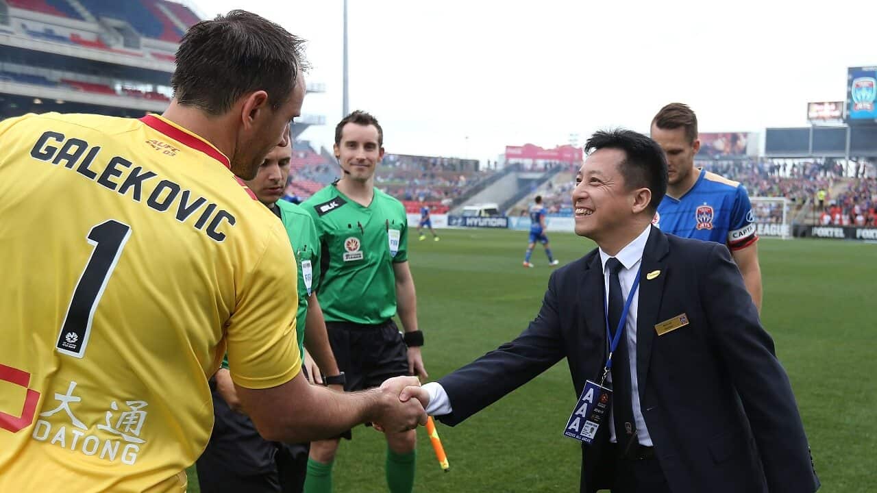Newcastle Jets owner Martin Lee shakes hands with Eugene Galekovic before a match