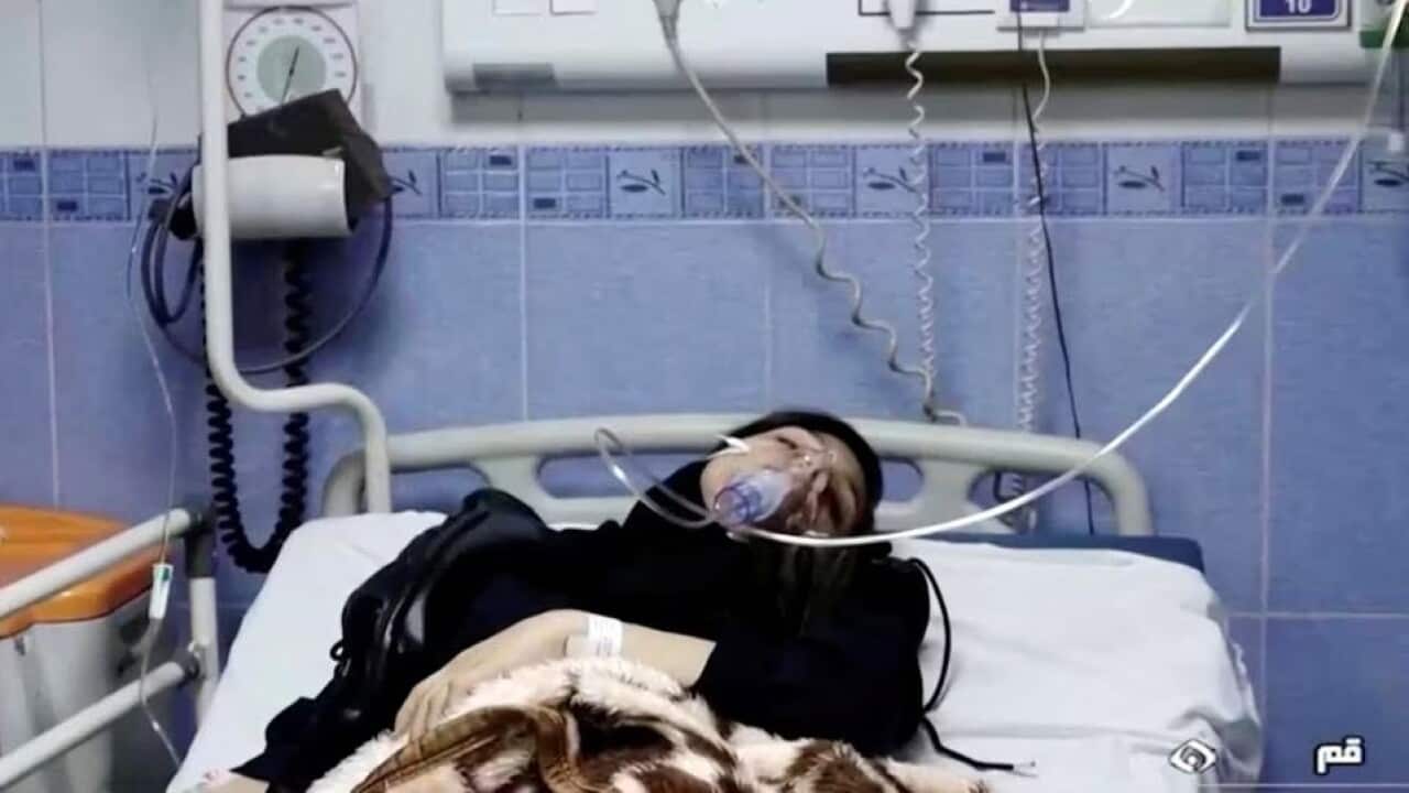 A young woman lying in a hospital bed with an oxygen mask over her face