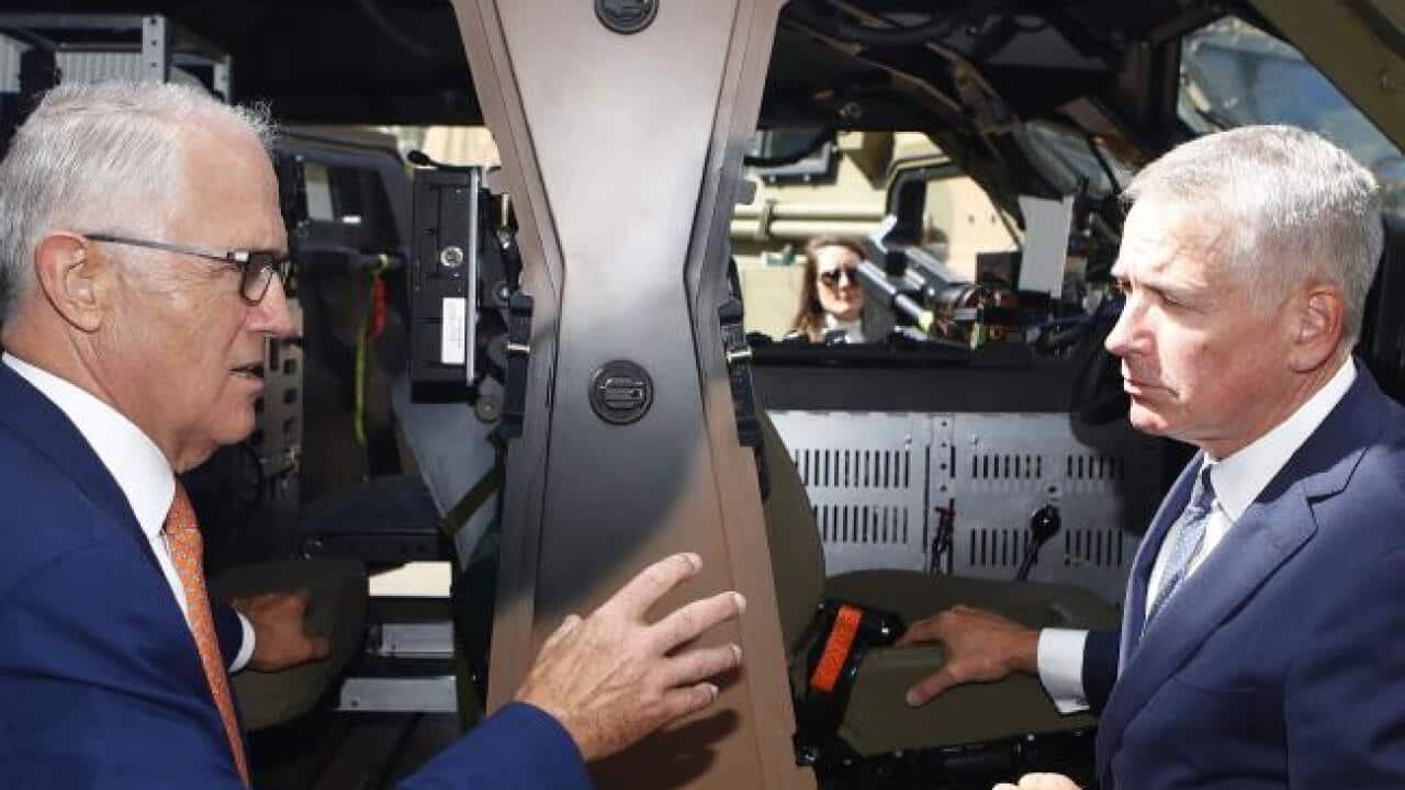 Prime Minister Malcolm Turnbull talks to Thales CEO Chris Jenkins next to the military truck Hawkei during a visit to Thales Underwater Systems in Sydney