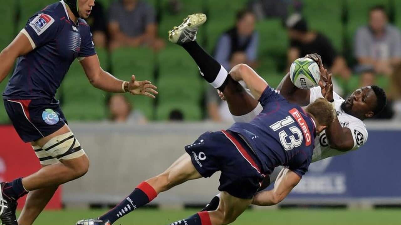 Lwazi Mvovo of the Sharks is tackled by Reece Hodge of the Rebels