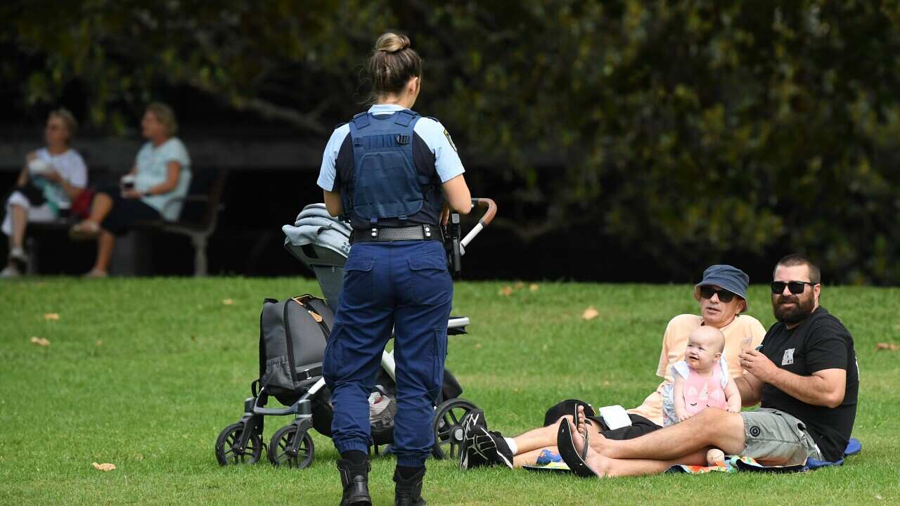 NSW Police officers ask a family to move on while on patrol at Rushcutters Bay park in Sydney.
