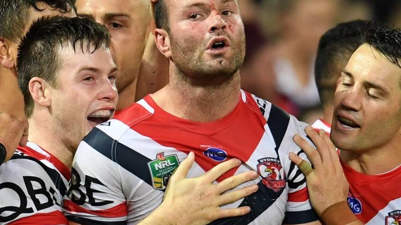 A file image of Boyd Cordner of the Roosters embraced by teammates,