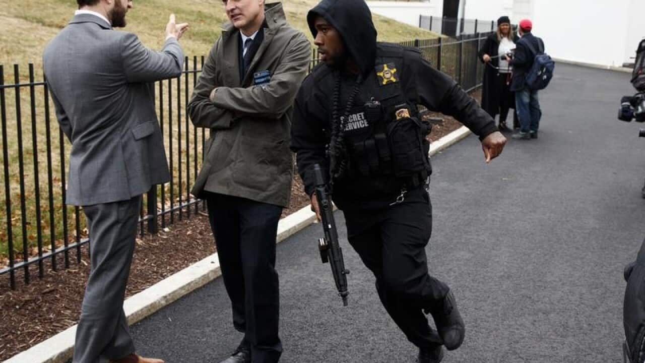 A Secret Service officer rushes past reporters