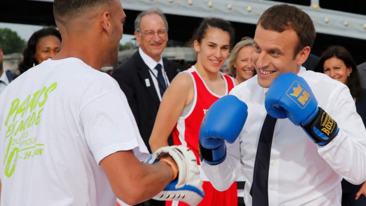 French President Emmanuel Macron spars with a boxing partner in Paris