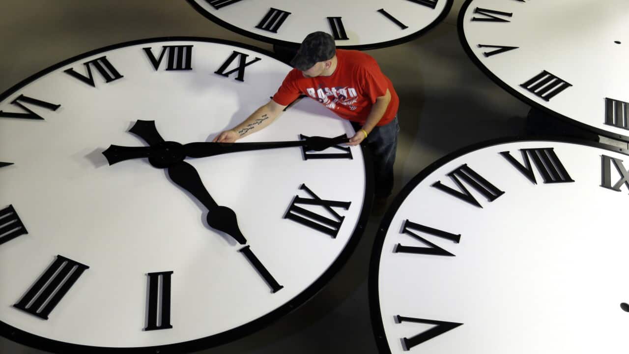 Dan LaMoore sizes hands for an 8-foot diameter silhouette clock at Electric Time Co., in Medfield, Mass. (AP Photo/Elise Amendola)