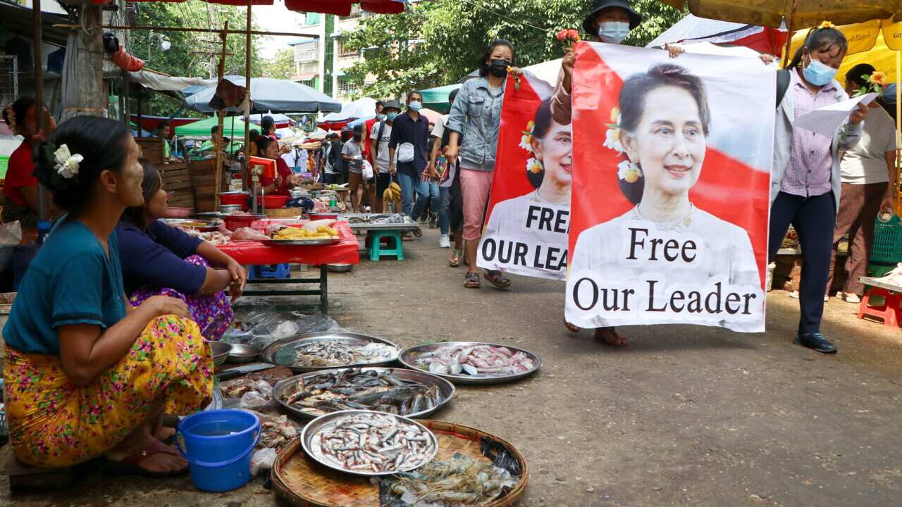 Anti-coup protesters walk through a market (AAP).jpg